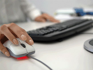 Mujer utilizando mouse en su computadora de trabajo